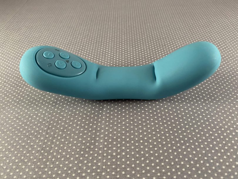 Close up view of bent Poco by Mystery Vibe on gray background, turquoise vibrator shaped similarly to a finger