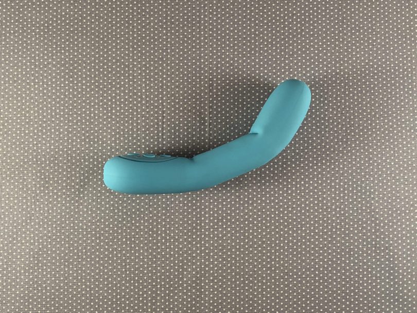 Side bent view of Poco by Mystery Vibe on gray background, turquoise vibrator shaped similarly to a finger