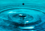 water droplet creating ripples in blue water as a concept for meditation