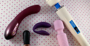 blog image for 5 Vibrators My Clit loves with the Kurve, Chorus, Digit, Pink BOB, and Original Magic Wand placed on a background of pink flowers on white fabric